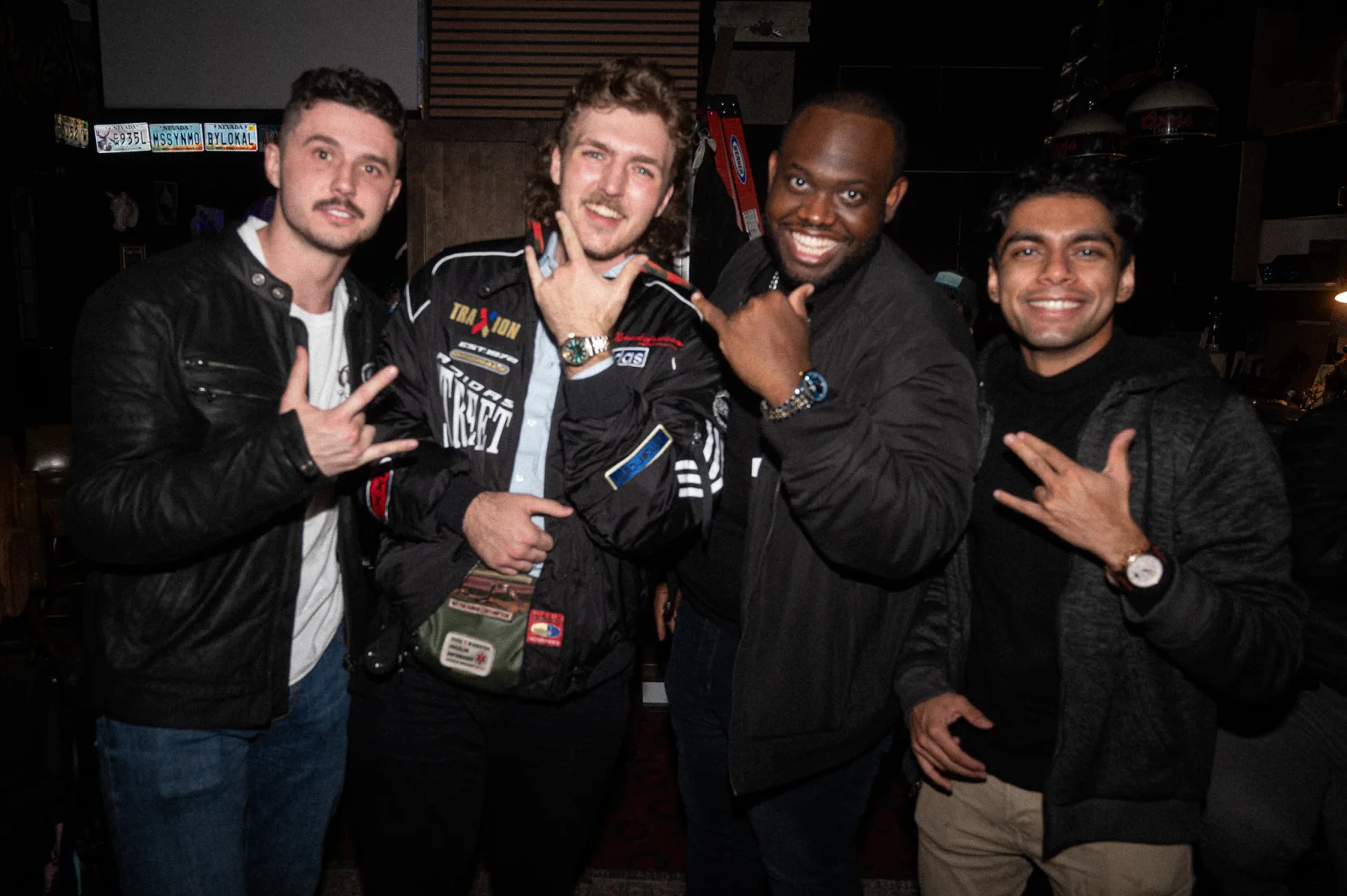 Anton and three friends smiling together on a night out.