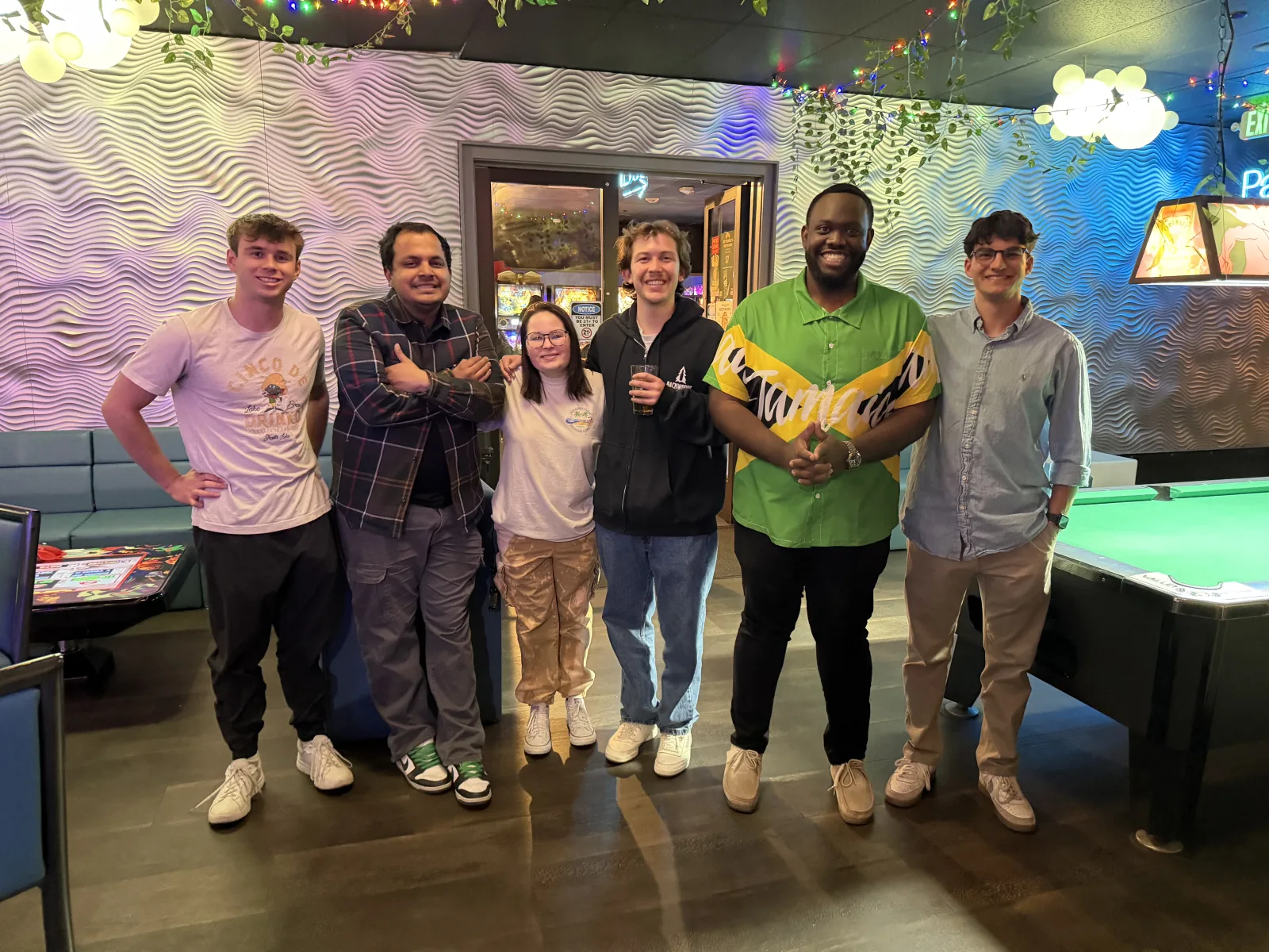 Anton and friends gathered beside a pool table.